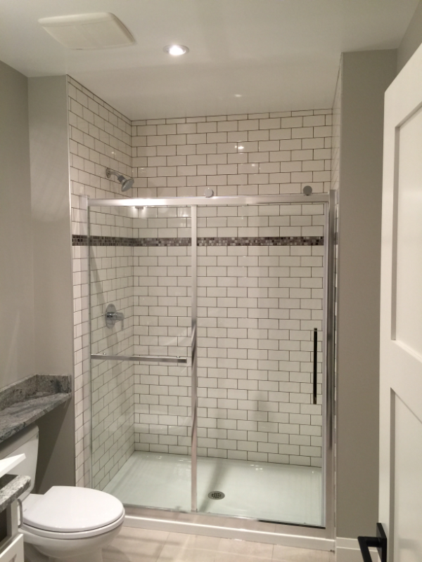 fiberglass shower surround subway tile with mosaic insert.