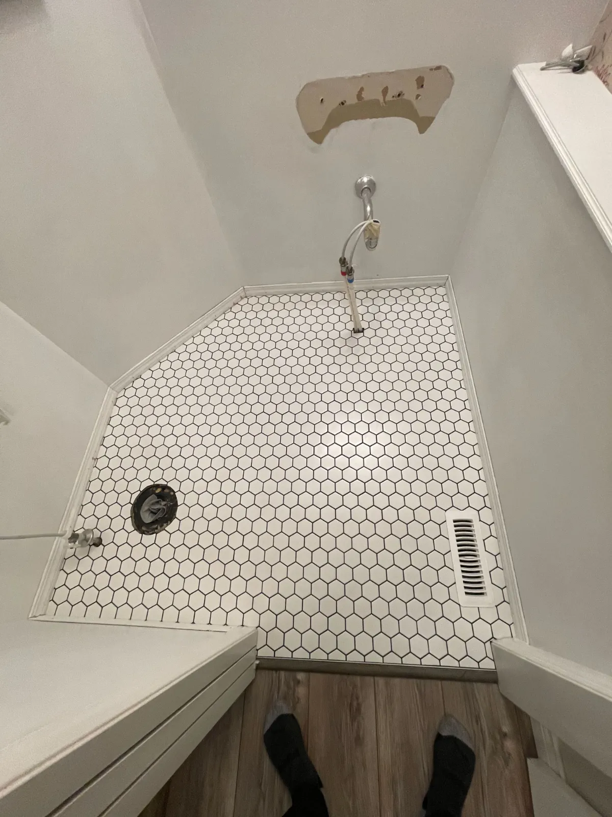 hexagonal mosaic matte white tile installed grouted and baseboard finished