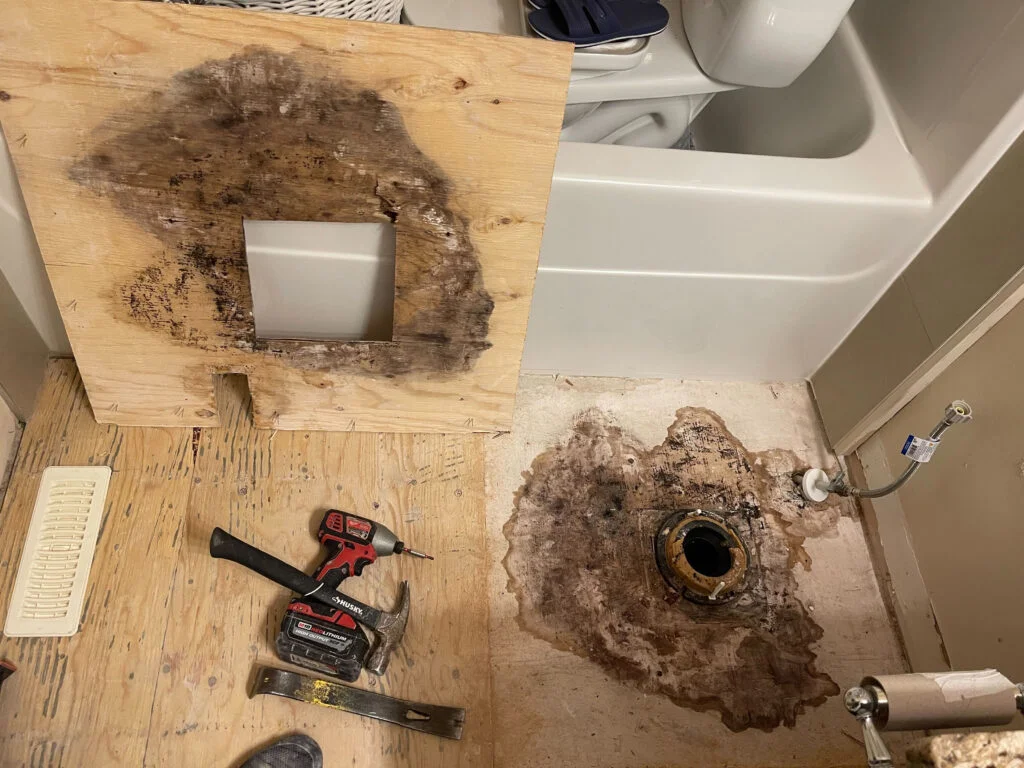 rot floor after toilet wax seal dried out due to months without use. tile damage